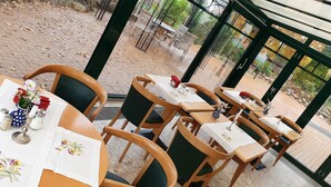 An outdoor dining area with tables set for two, featuring floral tablecloths and salt and pepper shakers. - Kur- & Landhotel Borstel-Treff (Dabel)