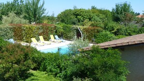 Ein Poolbereich mit Liegestühlen und einer Pergola.