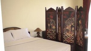 A neatly made bed with white linens, a wooden headboard, and a nightstand with a lamp. - Apartment/ flat - Koh samui (Koh Samui)