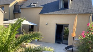 A residential house with a patio, a sliding glass door, and a small window with a view of the interior. - 3-STAR FISHERMAN'S STYLE HOUSE IN CANCALE 300M FROM THE PORT QUIET AREA (Cancale)
