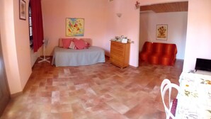 Un dormitorio con cama, cómoda y una silla roja.