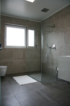 Een bad/douchecombinatie, een haardroger, handdoeken, zeep