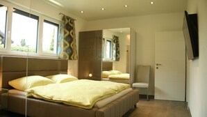 Een moderne slaapkamer met een bed, een spiegel en een deur.