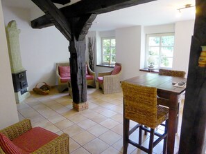 Een gezellige kamer met een open haard, rieten meubels en een eettafel.