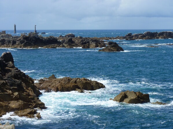 A coastal landscape with rocky formations and the sea.