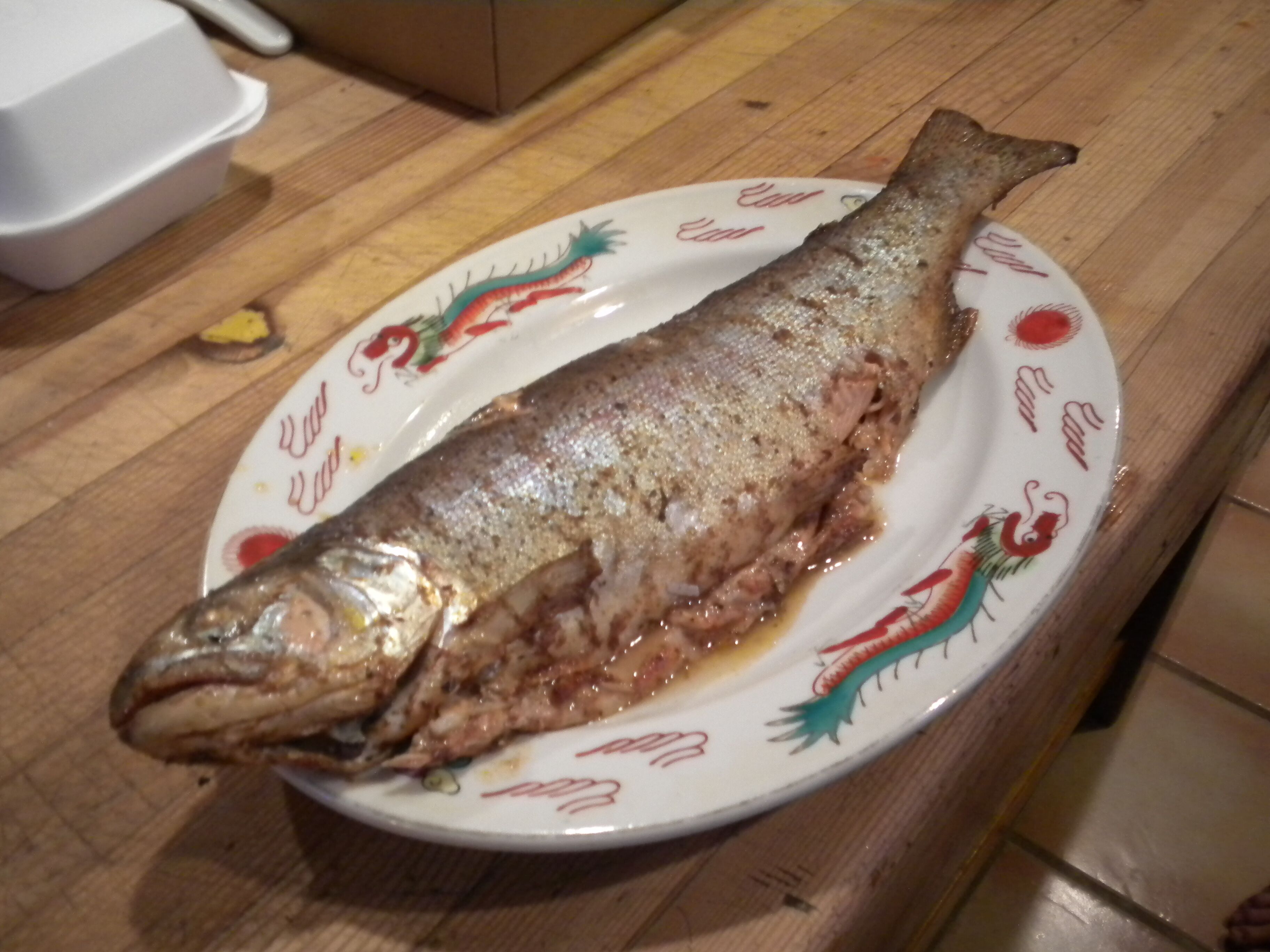 A whole fish on a decorative plate.