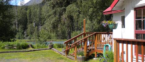 A wooden deck with a view of a lake and mountains.