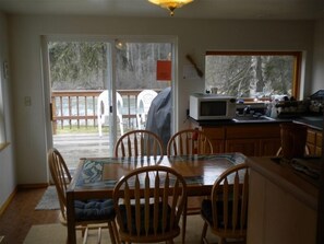 Enjoy meals in the kitchen with a dining area featuring a table and chairs, and a large window offering a view of the outdoors.