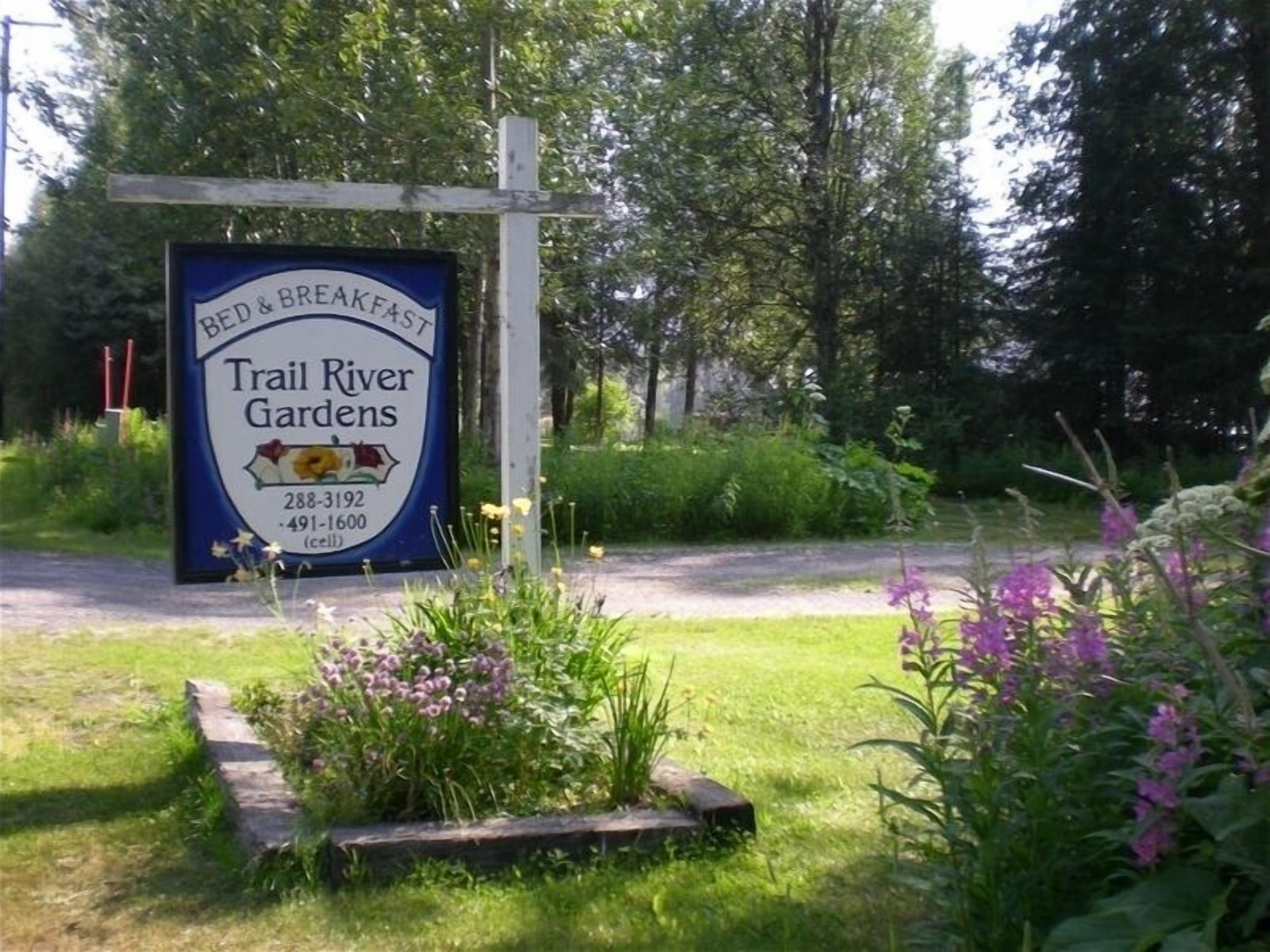 A sign for Trail River Gardens, a bed and breakfast, with contact numbers.