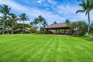 A well-maintained lawn with a pavilion and palm trees. - 🏖️Mauna Lani Golf Course Townhome w/ Beach Club Access | Kulalani 802 (Kamuela)