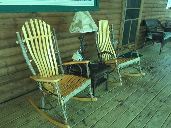 A wooden rocking chair and a chair with a lamp on a porch with wooden flooring. - Hickory Grove Cabin On 8 Acres With Private Fishing Pond. (Rockbridge)