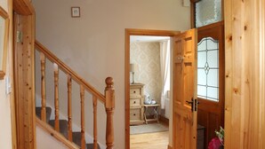 A wooden staircase leading to a room with a radiator and a dresser. - Cois Ba House (Dublin)