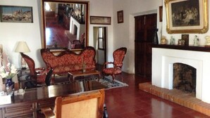 Un salón tradicional con chimenea, un espejo grande y muebles clásicos.