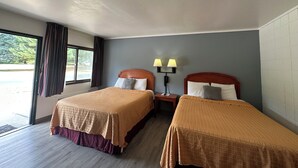 A hotel room with two beds, a window with curtains, a nightstand with a lamp, and a wall-mounted phone. - Skyview Motel (Prairie du Sac)
