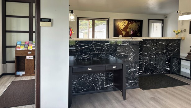 A modern kitchen with a marble countertop, a black desk, and a world map on the wall. - Skyview Motel (Prairie du Sac)