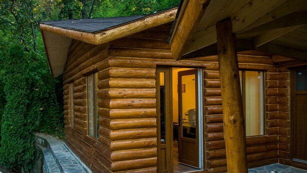 A log cabin with a stone-paved entrance and a covered porch. - Vila Flora Viseu de Jos (Viseu de Jos)
