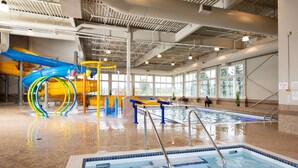 An indoor swimming pool with a water slide and a separate pool area. - Pomeroy Inn & Suites Prince George (Prince George)
