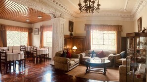 Amplia sala de estar con comedor, pisos de madera y decoración clásica.