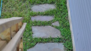 A wooden staircase with stone steps leading down to a grassy area. - New Loft w/South River view from treehouse deck! (Riva)