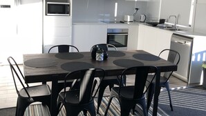 A modern kitchen with white cabinets, a built-in microwave, and a dishwasher.