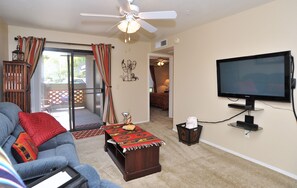 Relax in a cozy seating area with a sofa, coffee table, and flat-screen TV.
