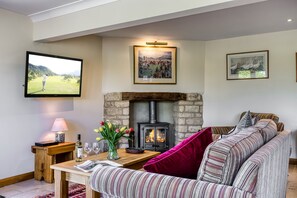A cozy living room with a fireplace, a television, and a comfortable sofa.