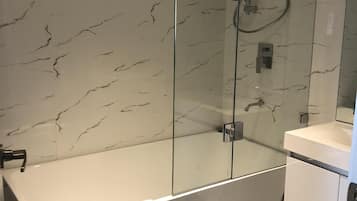 Combined shower/bathtub, towels, toilet paper