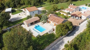 A residential area with multiple houses, a swimming pool, and a well-maintained lawn. - LUX CASA HISTRIA I - with heated swimming pool & jacuzzi (Pazin)