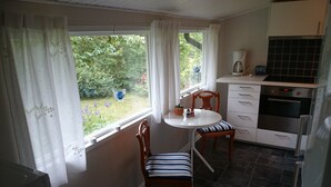 A kitchen with a dining table and chairs, a coffee maker, and an oven. - Cozy cottage near the lake, including free Wi-Fi and own rowing boat (Hallaryd)