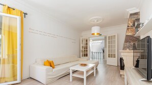 A modern living room with a white sofa, a coffee table, and a TV. - Lovely Farm with Pool @30min Lisbon and Beaches (Palmela)