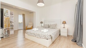 A modern bedroom with a large bed, bedside tables, a wardrobe, and a view of the outdoors. - Lovely Farm with Pool @30min Lisbon and Beaches (Palmela)