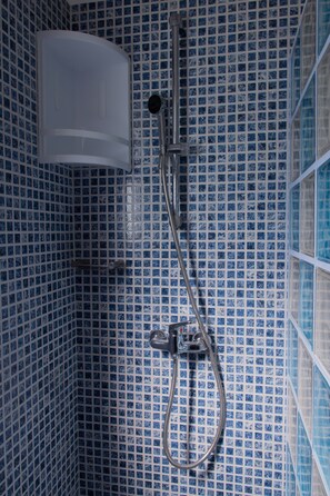Tina con regadera, secadora de cabello, toallas, papel de baño 