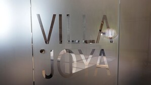 Une porte en verre dépoli sur laquelle est gravé, dans une police de caractères moderne, le nom « VILLA JOVA ».