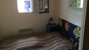 Una camera da letto con un letto, una finestra, una scrivania e una sedia.