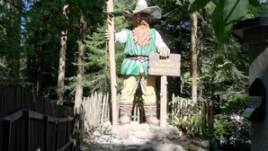 Een standbeeld van een man in traditionele kledij, met een bord waarop staat: Reitzitpark RUHPOLDING.