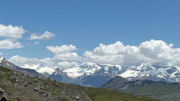 A mountainous landscape with snow-capped peaks and a clear sky.