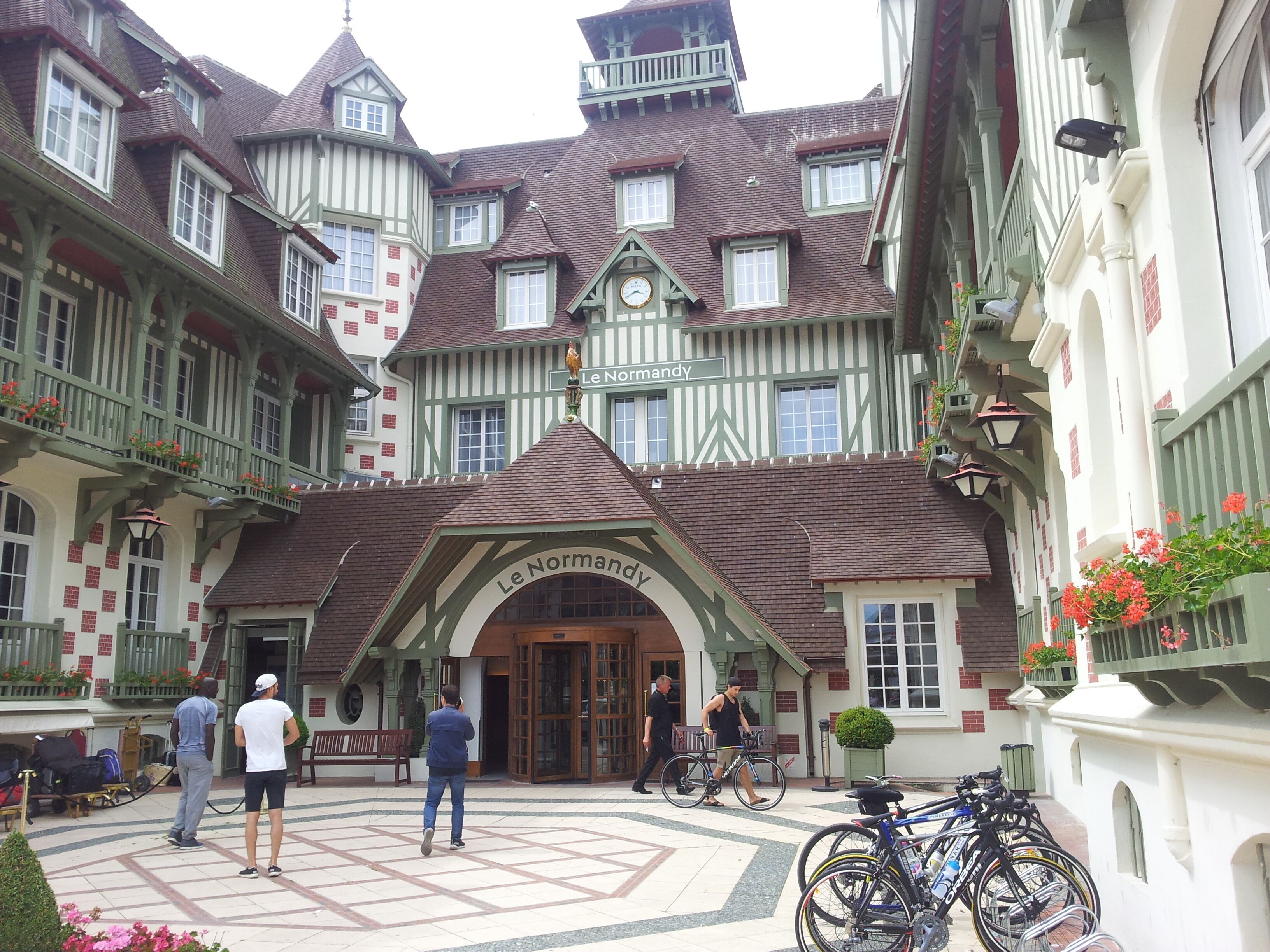 A traditional European building with a central entrance, multiple windows, and a sign reading "Le Normandy."