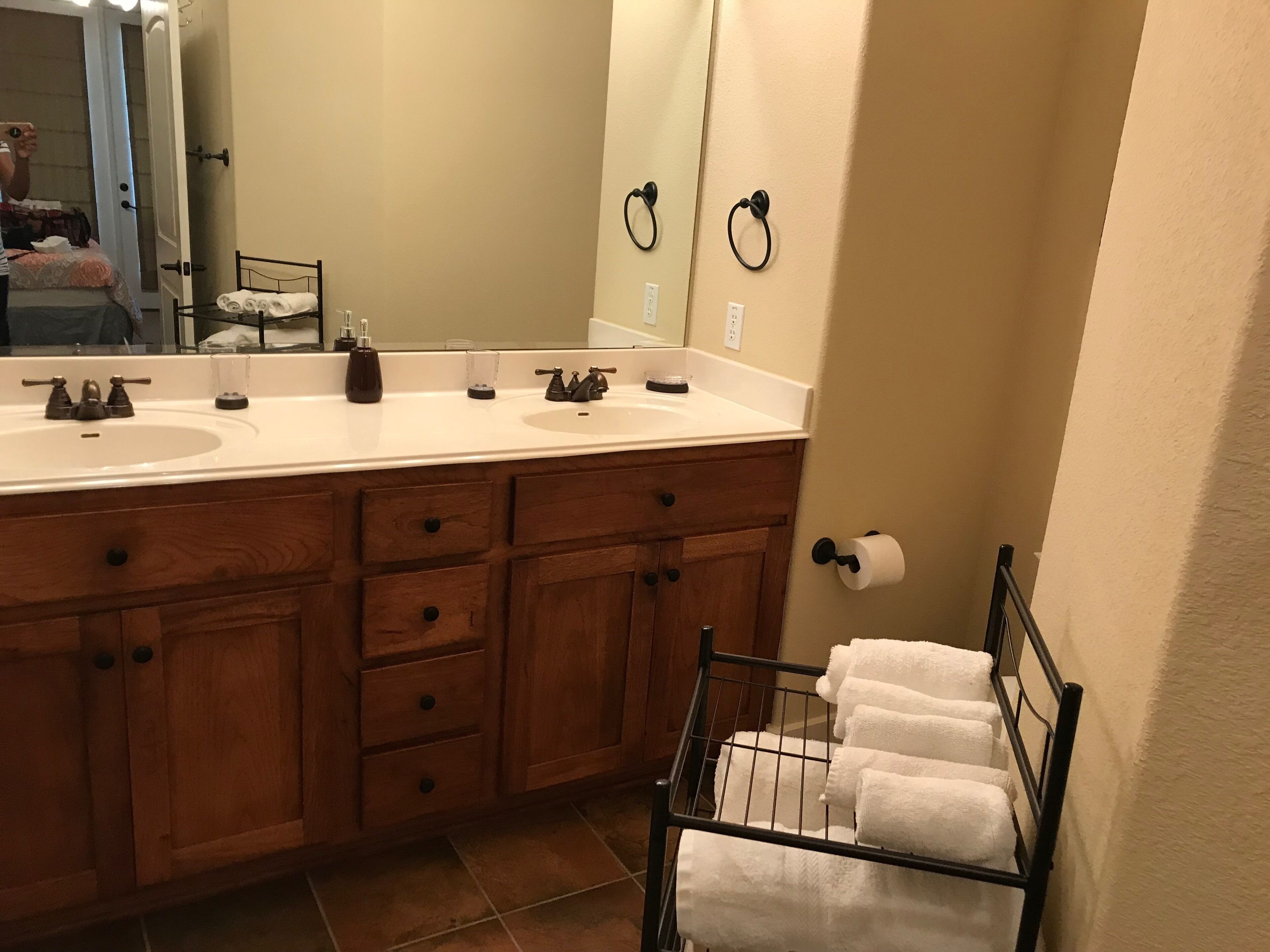 Une salle de bain avec deux lavabos, des meubles en bois, un porte-serviettes et un miroir.