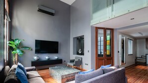 Ein modernes Wohnzimmer mit Flachbildfernseher, Couchtisch und zwei Sofas.