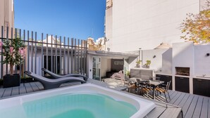 Ein Poolbereich auf dem Dach mit Whirlpool, Sitzgelegenheiten im Freien und einem Grill.