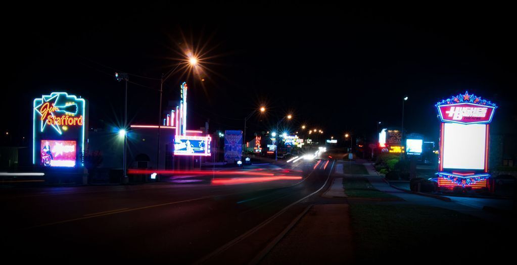 A nighttime street scene with neon signs and streetlights.