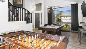 A modern living room with a foosball table, a pool table, and a staircase. - SWSS 5BR Kierland-Area Luxury Home | Heated Pool, Putting Green & Outdoor Living (Scottsdale)