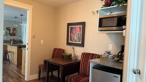A compact kitchen with a refrigerator, microwave, and a dining area with striped chairs. - All One Level Basement Unit Large Great Room Kitchen 3 bed 2 baths (Lava Hot Springs)