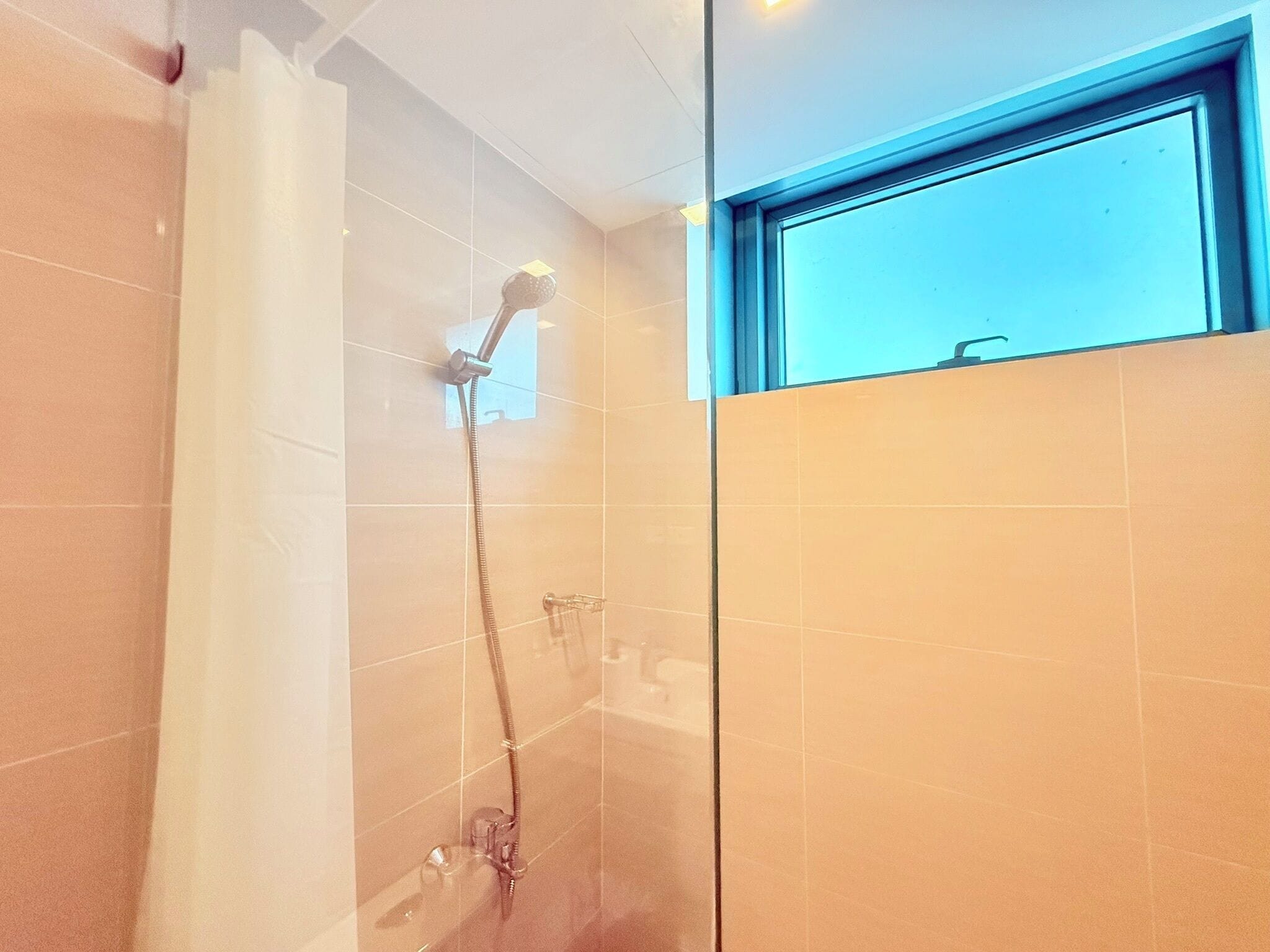 A shower with a handheld showerhead and a wall-mounted faucet.