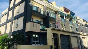A multi-story building with balconies, large windows, and a sign indicating a restaurant. - Coffee Bear (Hengchun)