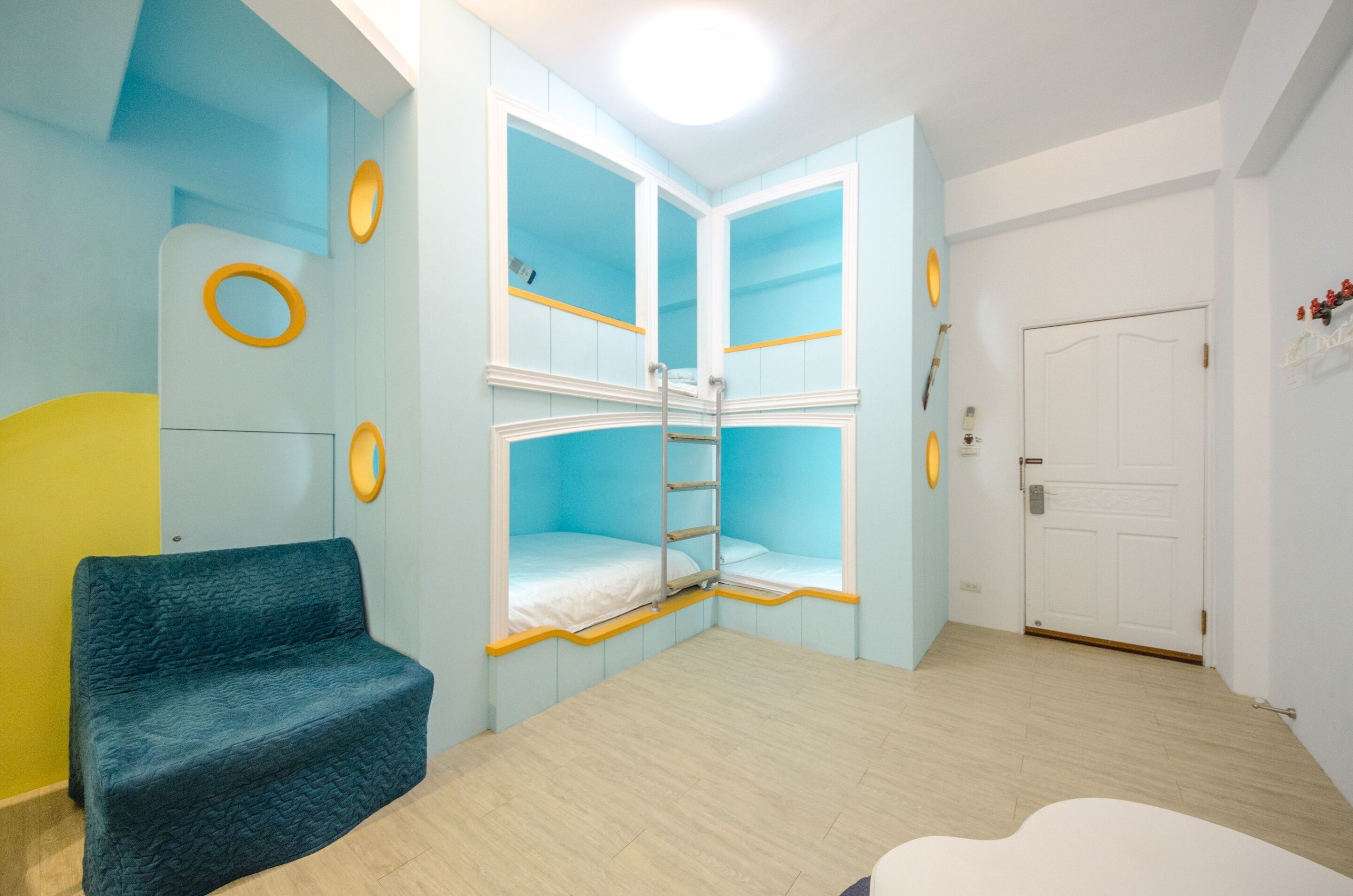 Ein Zimmer mit einem Etagenbett, einer Schlafcouch und einer Tür.
