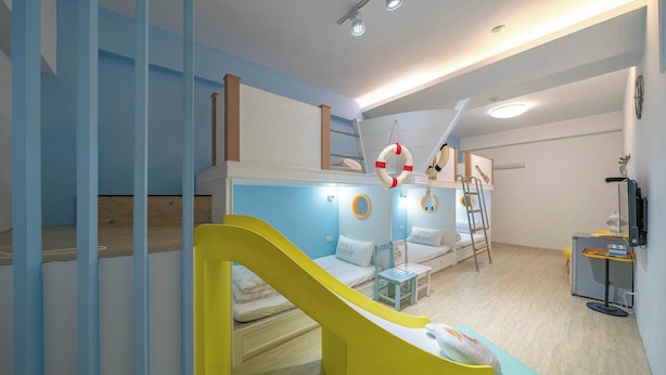Ein Kinderspielbereich mit Rutsche, einer Couch und einem kleinen Tisch.