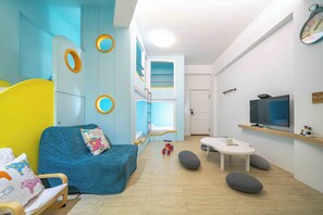 A modern living room with a blue sofa, a small table, and a television.