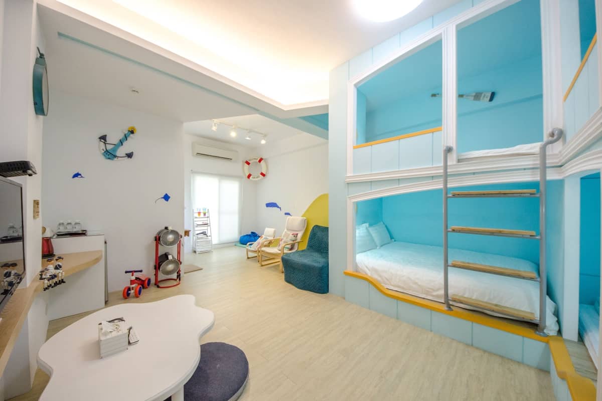 Quarto ideal para crianças, com beliches, espaço de recreação e cozinha compacta.