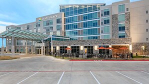 Een modern Hyatt Place hotel met een overdekte entree, een terras en een parkeerplaats.